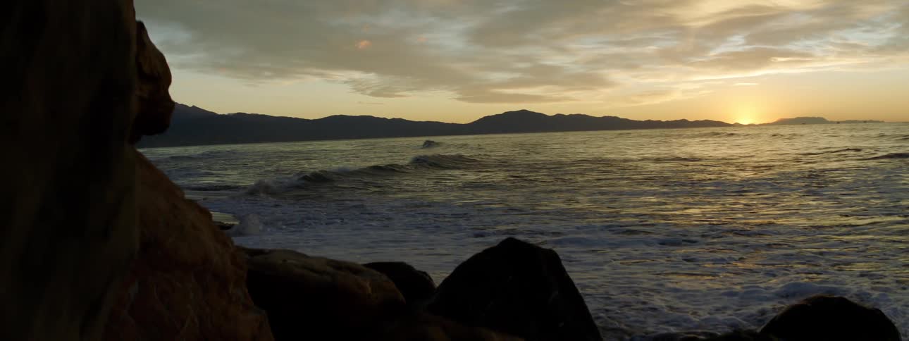 Waves lapping onto a beach at sunset