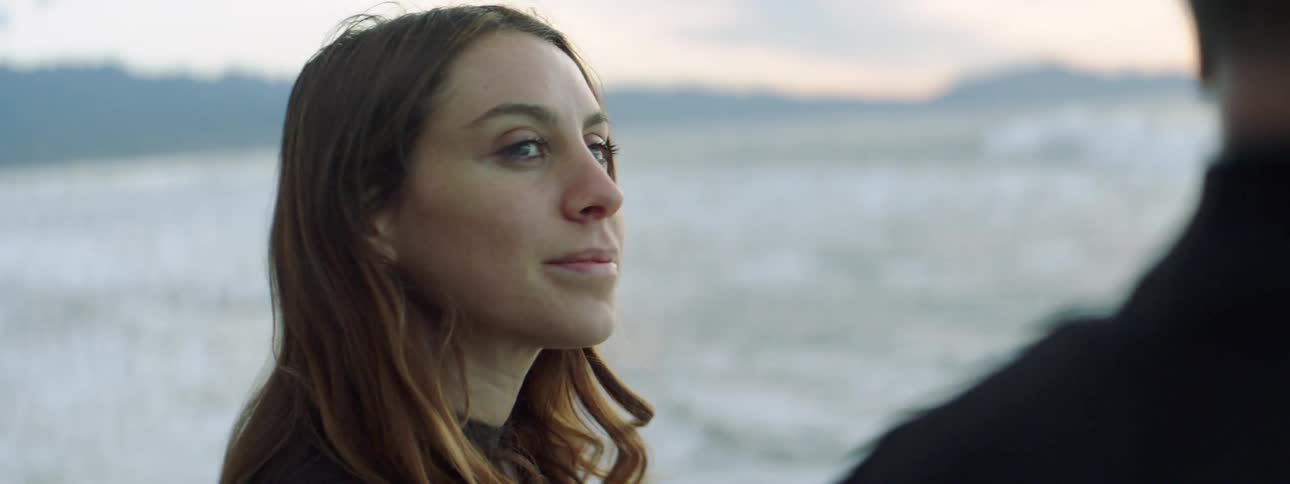 A man and woman stand on the beach together