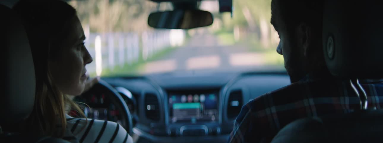 A man and woman are driving a car