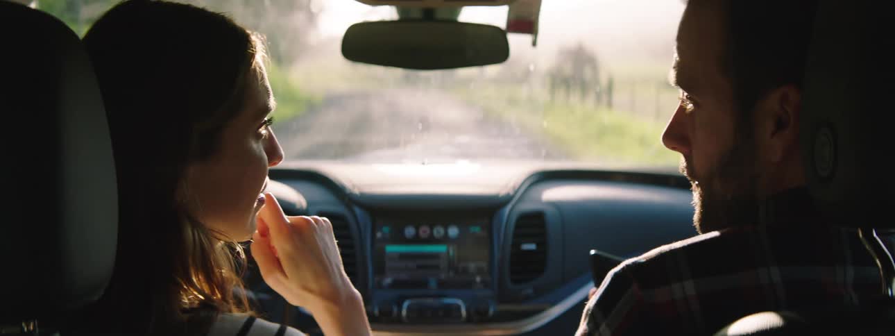 A man and woman talk while driving in the car