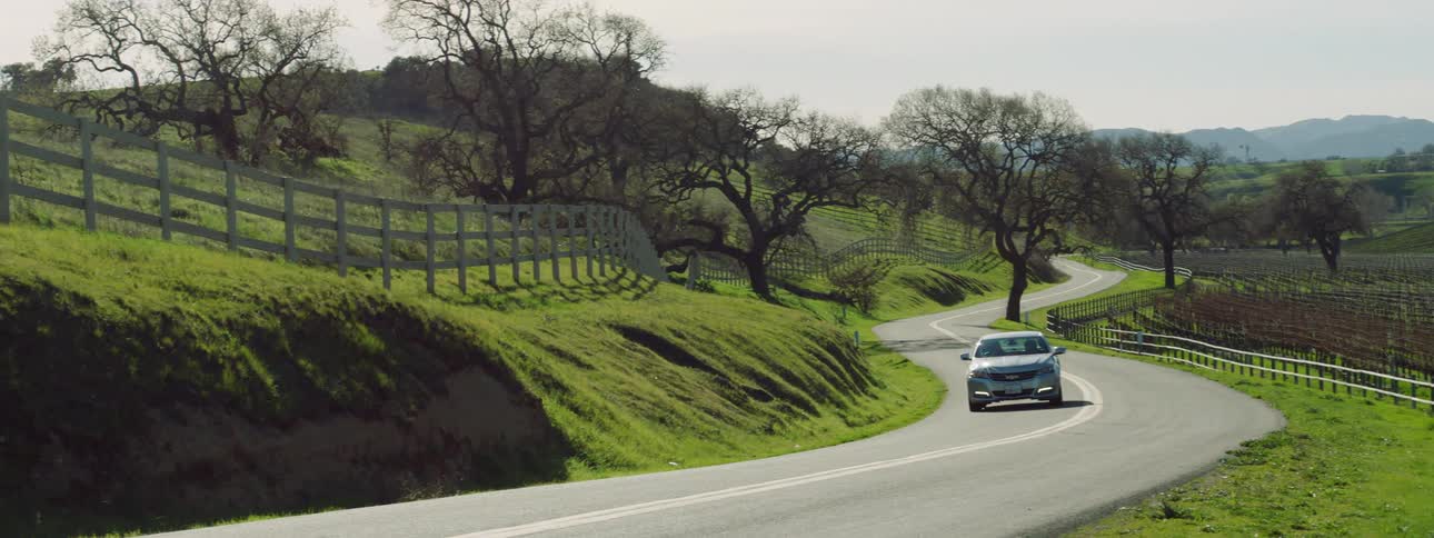 A car is driving through a rural area