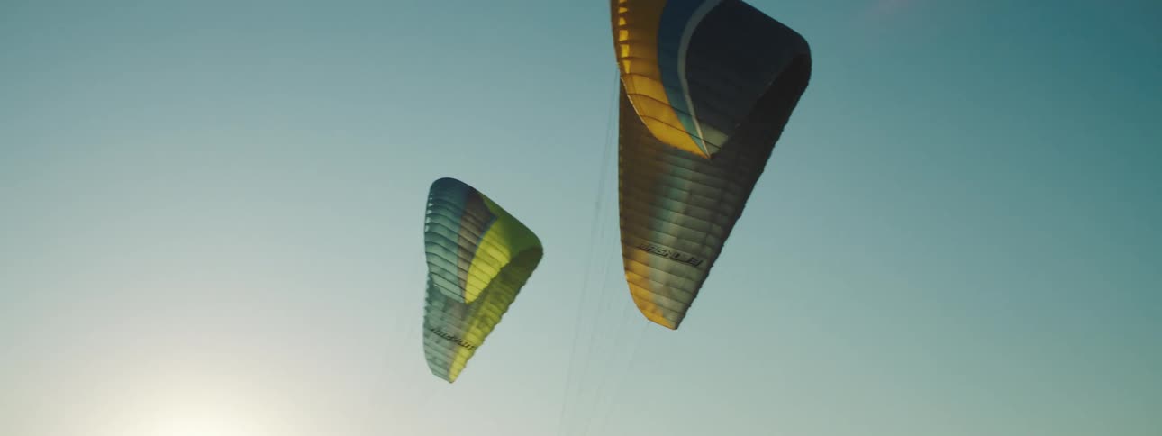 Two parachutes fly in the sky