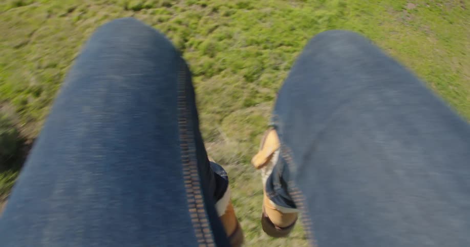 Woman runs off a hill on a parachute