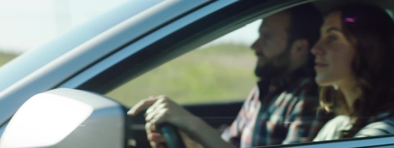 A man and woman are driving past a farm