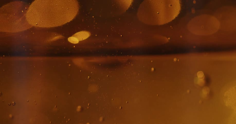 Close up of honey with bubbles flowing on a glass jar