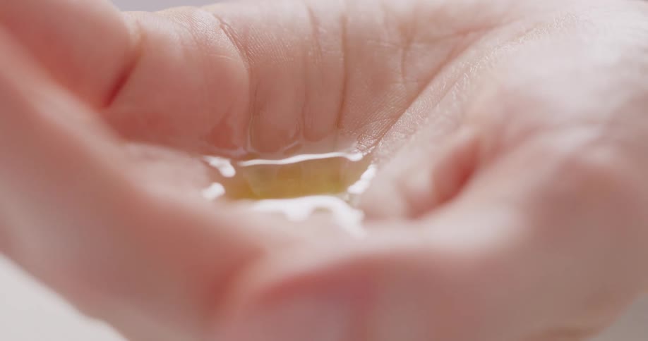 Liquid drips into the palm of a hand