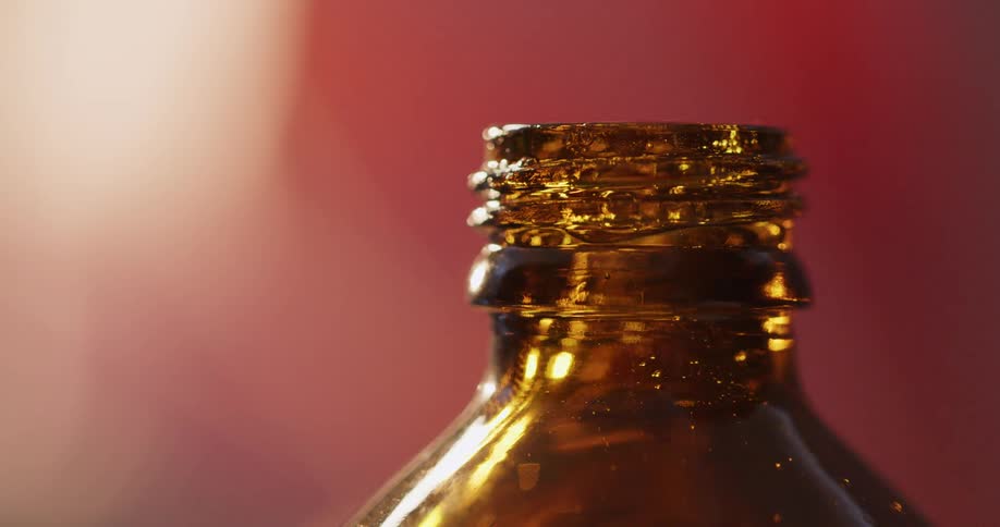 Close up of a bottle finish filled with honey