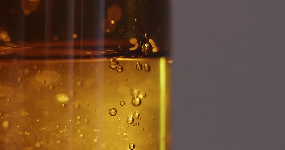 Honey flowing down the internal walls of a glass bottle