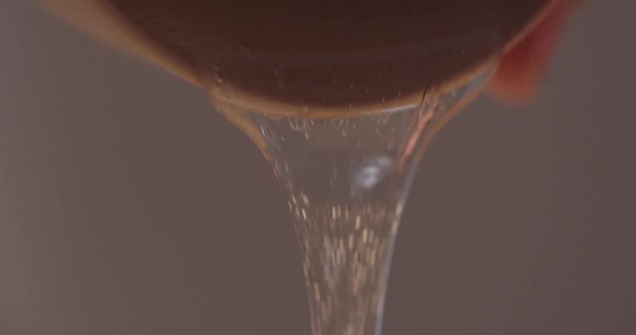 A person pouring liquid out of a cup