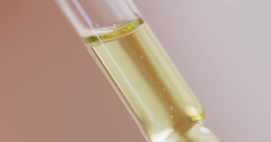 Small bubbles rise in the glass vial