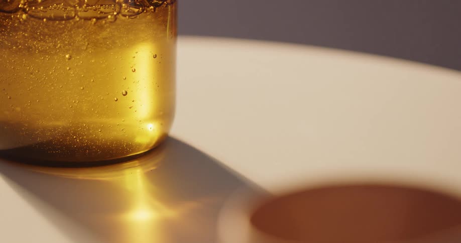 A person picking up a bottle with a gel from a table
