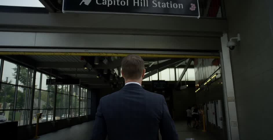 Man with a black suit and sunglasses enters capitol hill station