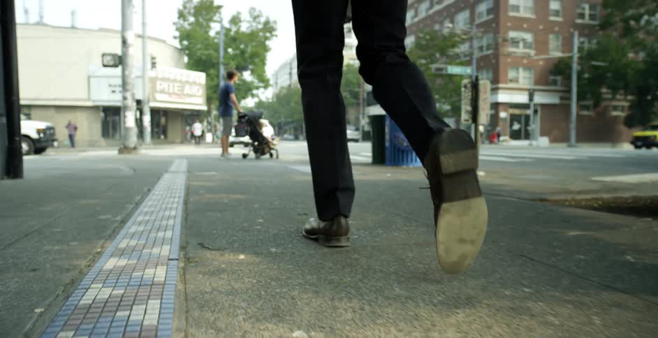 A man is walking through a downtown city