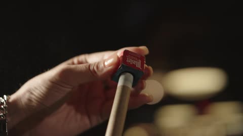A person is polishing their pool cue