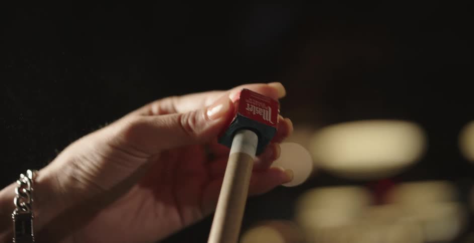 A person is polishing their pool cue