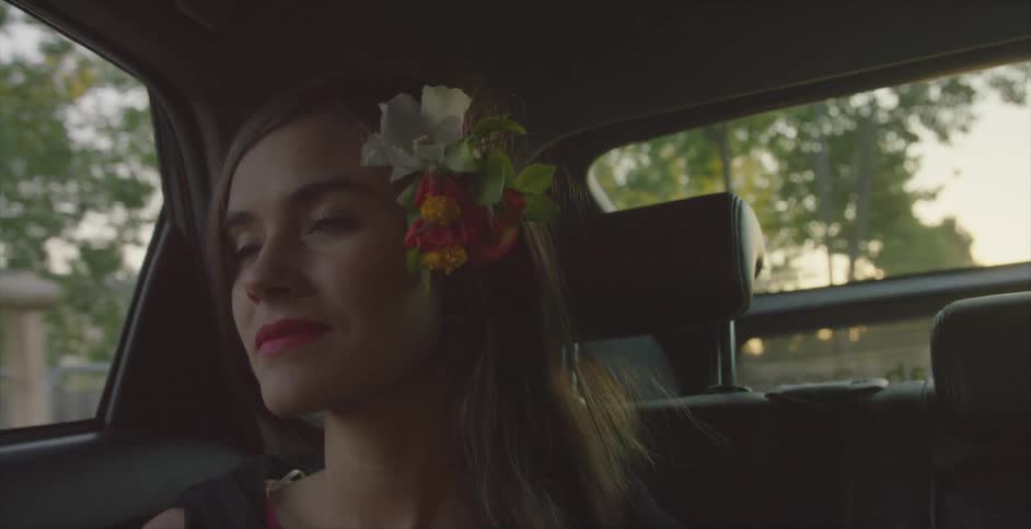 A woman is traveling in the passenger seat of a car smiling