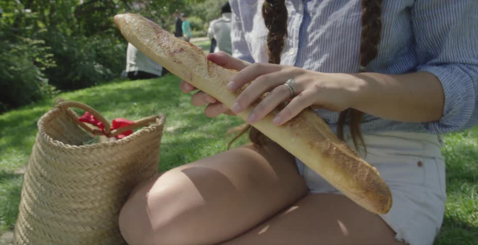 A woman removes a loaf of bread and places it on the ground