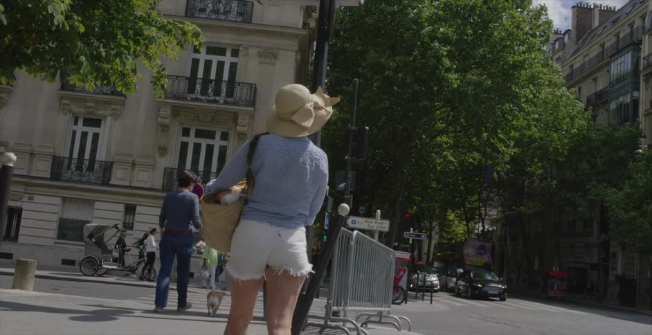 People are walking down a city street on a sunny day