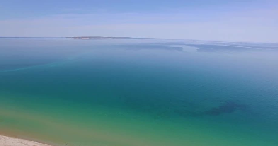 A beach and ocean seen from above on a clear sunny day