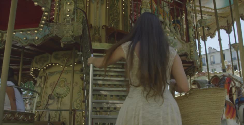 A woman climbing the stairs of a double carousel