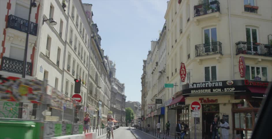 A vehicle passing by city streets with people all over