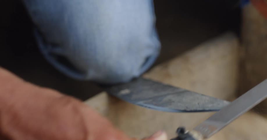 A man sharpens a blade on a knife