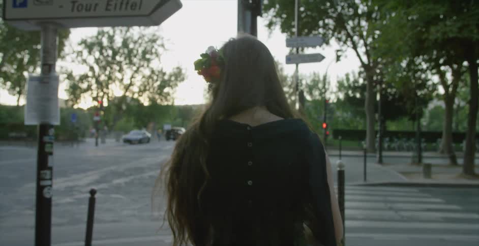 A woman walking along an urban sidewalk