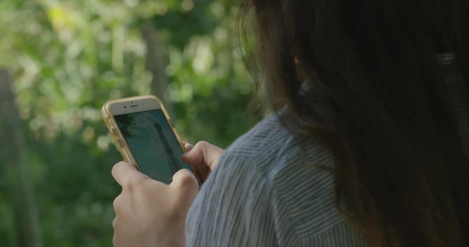A woman looking at pictures on her cell phone