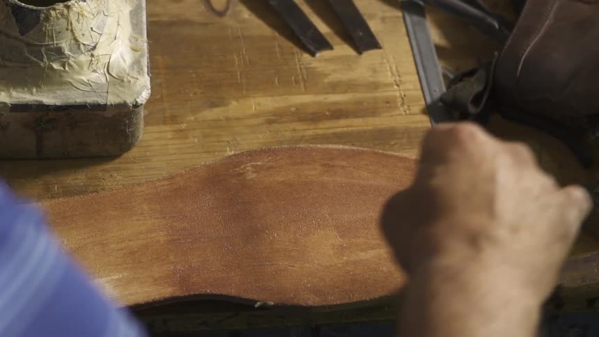 A man puts glue on the bottom of a shoe