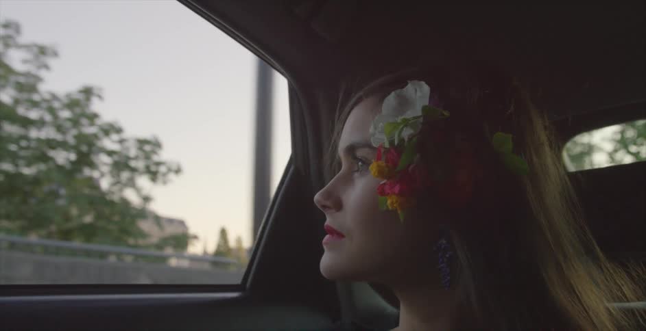 A woman is riding in a car looking out the window