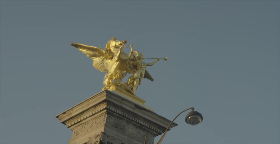 A gold statue sits on the top of a tall pillar