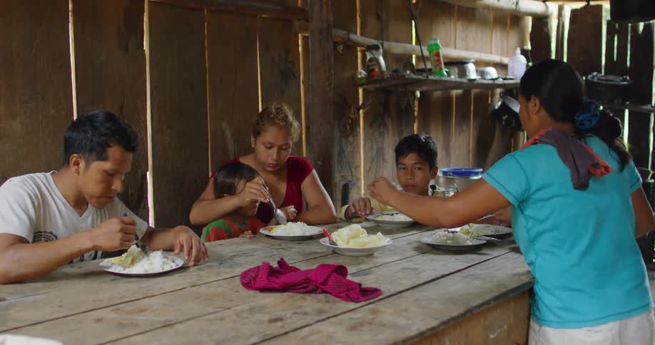 A family eating at a table in a rural area