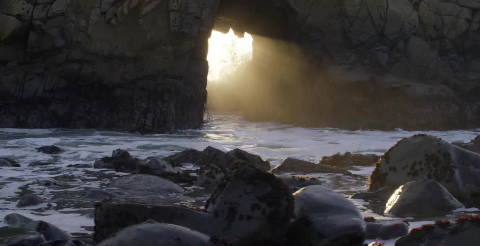 A cave near the coast with waves of water coming through the entrance