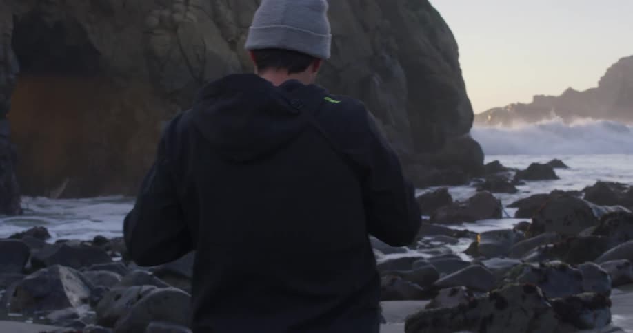 Two photographers takes pictures of waves crashing towards the shore