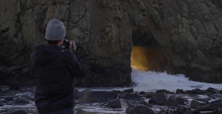 A man is taking photographs outdoors of a landscape