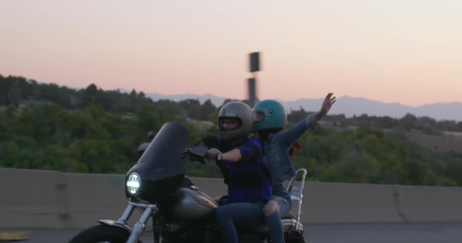 A man and woman ride a motorcycle on the highway