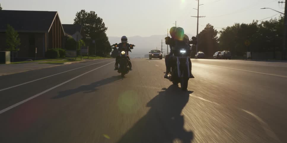 Motorcycles travel on the highway as cars go past