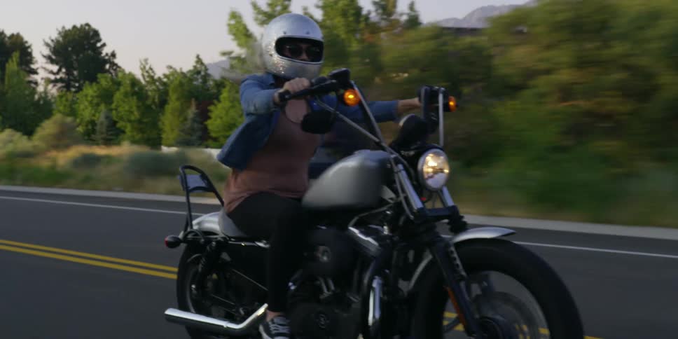 A woman is riding a motorcycle on a highway