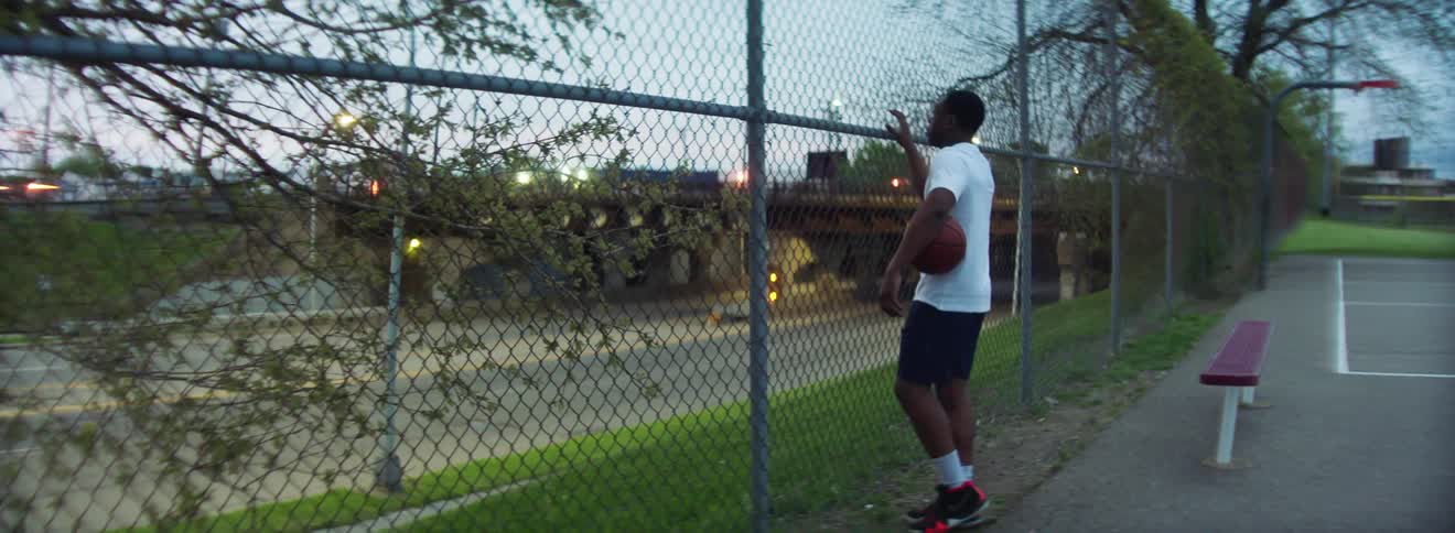 A man walks on the court over to the fence