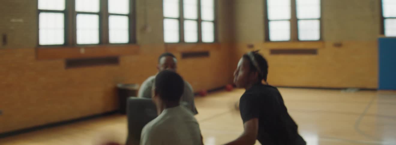A group of young men doing basketball drills in a gymnasium