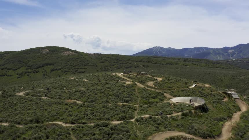 People biking on a trail in the hills