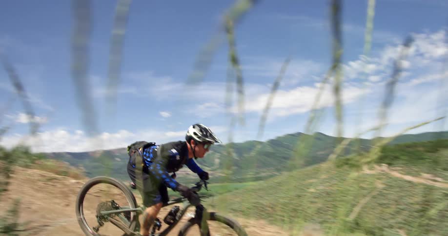 A man jumps off a ramp with his mountain bike
