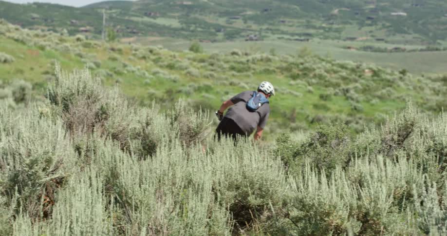 A man riding his bike down a large hill