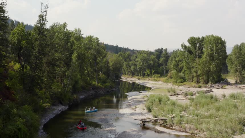 People paddling down a river in a boats