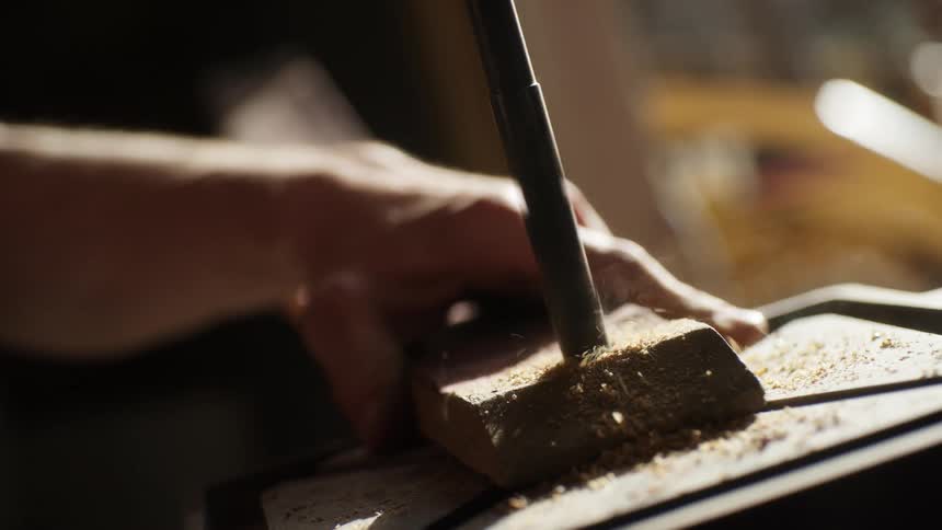 A person uses a drill on a piece of wood