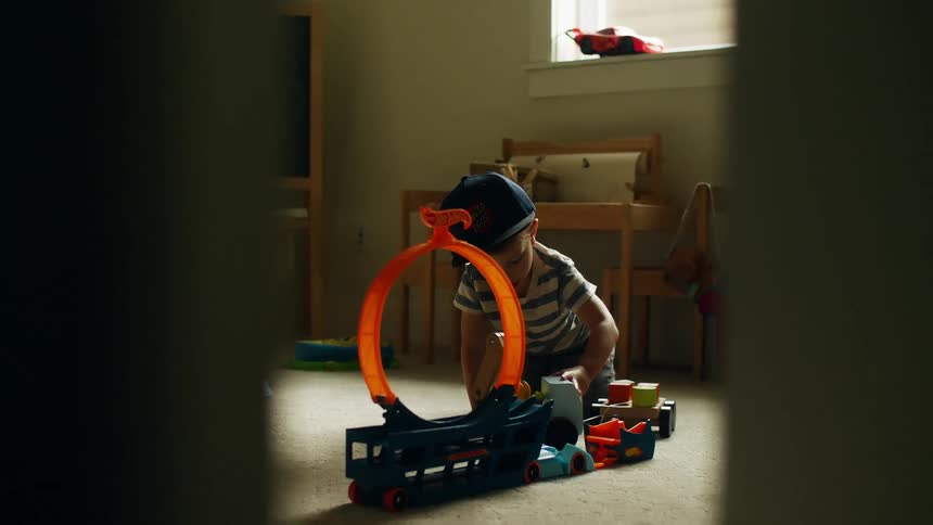 Male toddler pushes a play toy as he plays