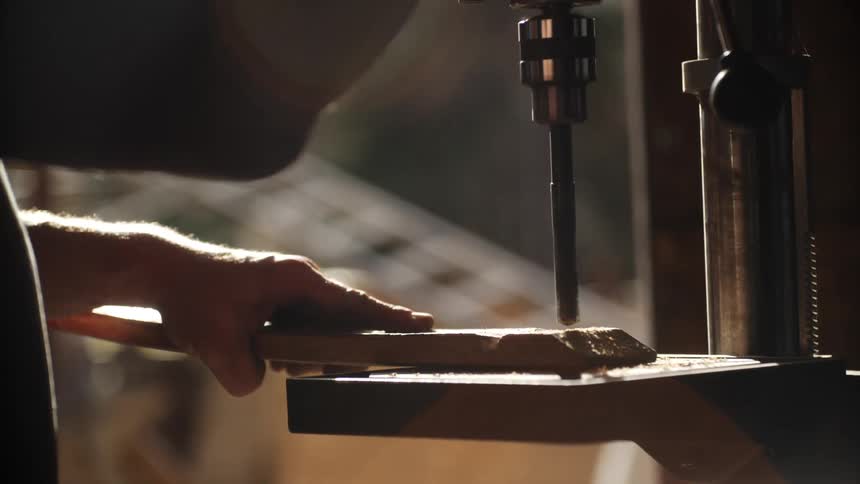 A man drilling through a piece of wood