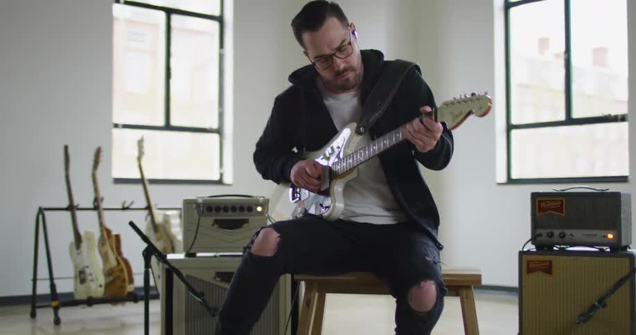 Man plays an electric guitar in a studio