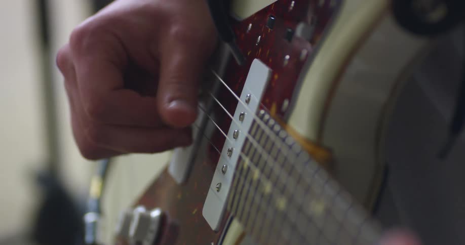 A guitarist strums on a guitar