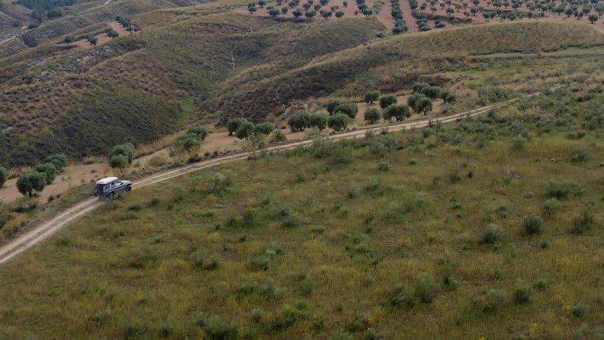 A vehicle drive son the small trail on the hill
